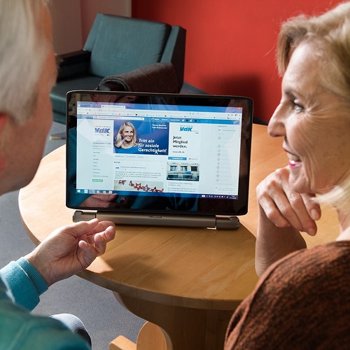 Online-Veranstaltungen für Ehrenamtliche: Zwei Menschen schauen in einen Bildschirm, auf dem die VdK-Seite zu sehen ist